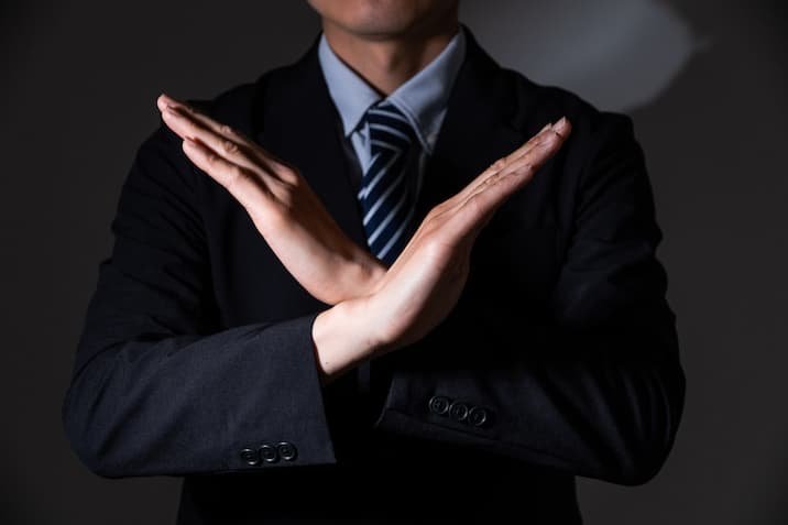 両手でバツを表現するビジネスマン
