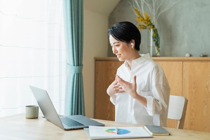 ノートPCの画面を見る笑顔の女性