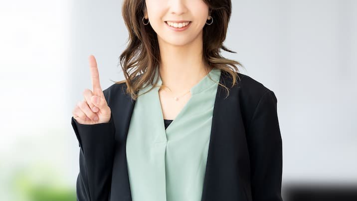 人差し指を立てるビジネスウーマン